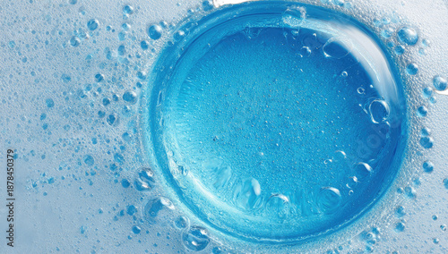 Close-up of a circular drain with blue liquid and overflowing foam