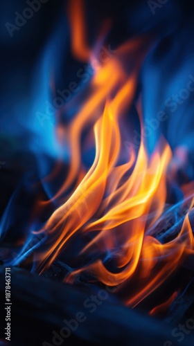 Fiery blue and orange flames twist and rise over dark embers, creating intense motion and heat.  intense glow!