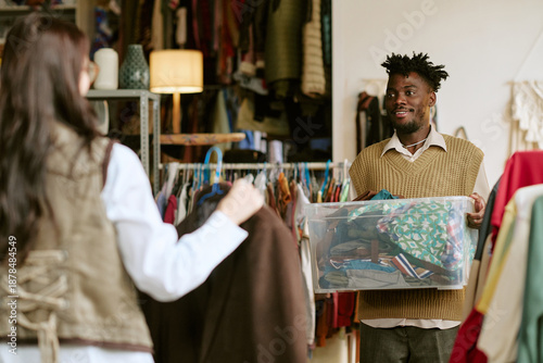 Εκτύπωση καμβά Young Black man holding plastic container filled with assorted second hand cloth