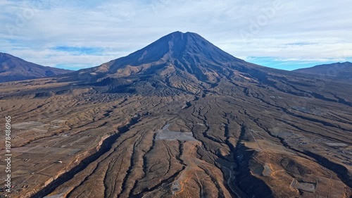 A reversing drone shot of Misti volcano near Arequipa, Peru, revealing massive lava flows spreading from the base of the volcano, showing the enormous scale of its last powerful eruption.