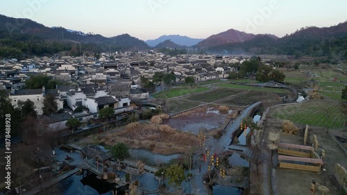 Xidi, China: Aerial drone footage of the famous Xidi ancient village in Anhui province in China. Shot at sunset above the field surrounding the village famous for old Hui architecture. 