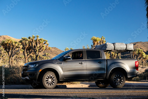 Foto Overland pickup truck parked on desert road under clear blue sky