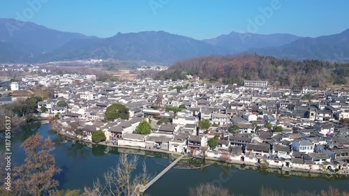 Hongcun, China: Aerial drone footage of Hongcun ancient village with its stone bridge in the countryside of Anhui province on a sunny day in winter in China