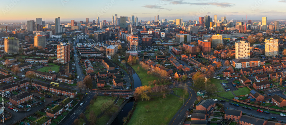 Naklejka premium Aerial image of Miles Platting Sunrise and the Ancoats Urban Corridor with Manchester Skyline on the Horizon. 