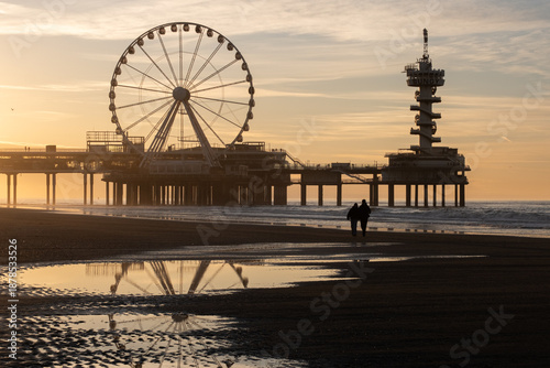 Quadro em tela A couple walking towards the pier during sunset at Scheveningen, The Hague