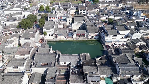 Hongcun, China: Aerial drone footage of the narrow alley and temple by the Moon Pool in the famous Hongcun ancient village in Anhui in winter in China. Shot with a backward motion