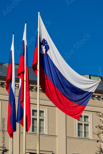 Foto slovenian flags on flagpoles against blue sky