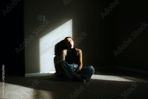 Woman Sitting on Floor Near Window with Soft Shadows and Light