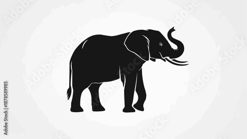 Silhouette of an African elephant with its trunk raised.