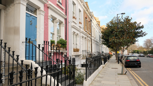 Typical Victorian terraced houses in England. Exterior view of cozy residential buildings in London with metal fence, several floors, windows and front door with molding. Real estate, Living apartment
