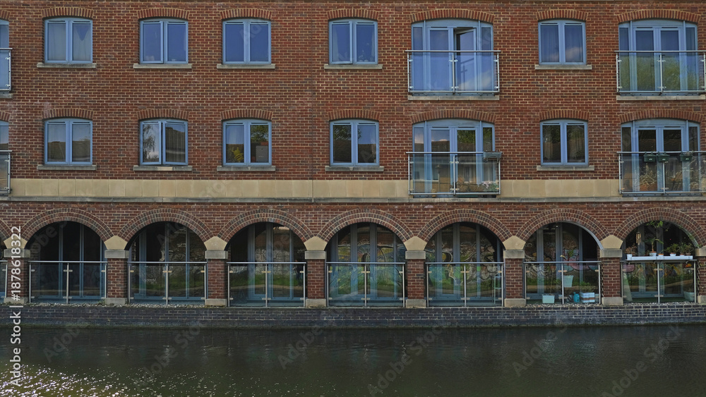 Fototapeta premium Exterior of brick Flats house object on Regents Canal in London, England. Real estate, residential apartments and offices. Living apartments or office building architecture
