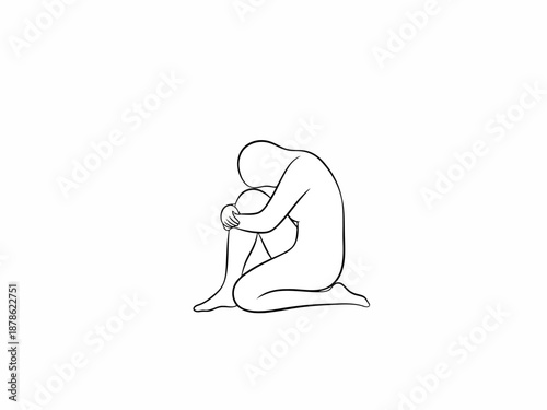 A person sitting alone in a contemplative or sad pose with their head down