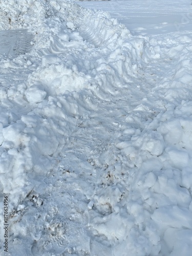 Car and tractor tread marks on snow in winter, tire prints.