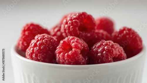 Ripe red raspberry closeup in ceramic bowl, fresh juicy texture and bright color