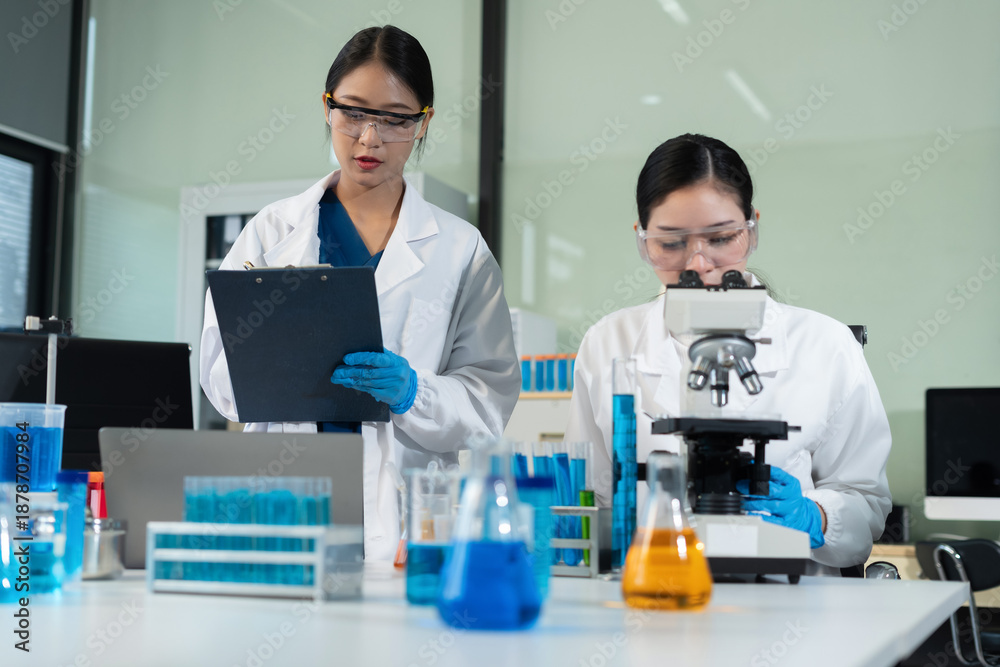 Fototapeta premium Scientists conducting research in a biotechnology lab, using pipettes and test tubes for medical and chemical experiments. Innovation in chemistry, healthcare, and medicine.