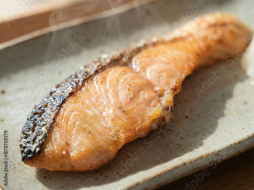 Extreme close-up of grilled salted salmon fillet with crispy skin and steam, macro food texture. 脂の乗った焼き鮭のアップ　湯気が立つ皮まで美味しい和食素材