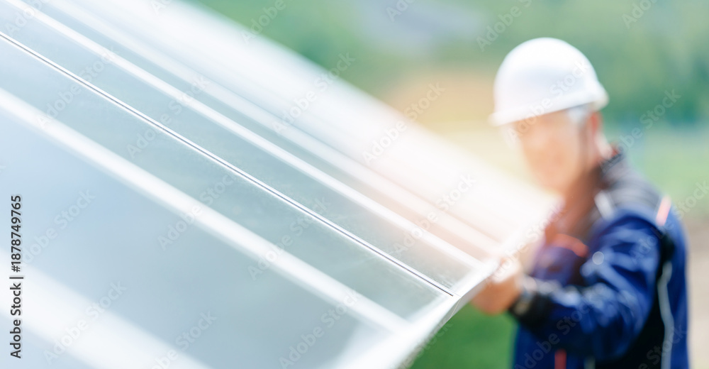 Fototapeta premium Male engineer inspecting solar panels on renewable energy installation site