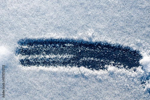 Close-up of snowy background with a hand-drawn stripe on a black background.