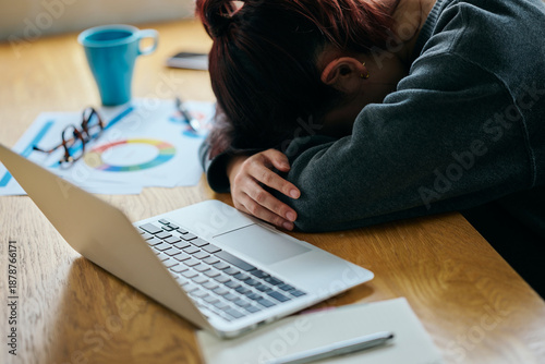 Tableau sur toile A young woman slumped at her desk