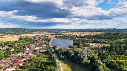 Scenic view of Tismana village in Gorj County Romania under a bright blue sky with fluffy clouds. A stunning landscape captures the beauty of Tismana village in Gorj County. Tismana, Romania.