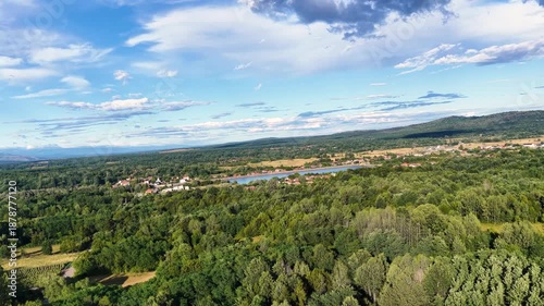 Scenic view of Tismana village in Gorj County Romania under a bright blue sky with fluffy clouds. A stunning landscape captures the beauty of Tismana village in Gorj County. Tismana, Romania.