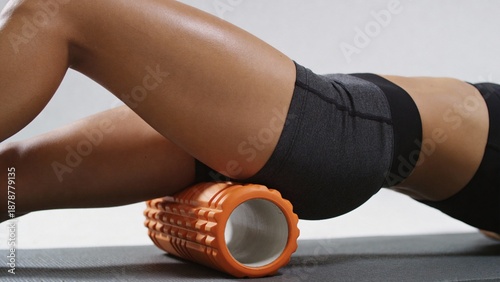 Athletic Woman Using Foam Roller for Muscle Recovery and Stretching