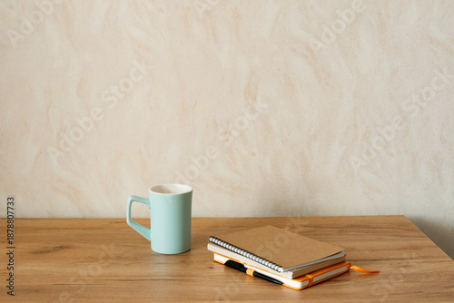 Close-up of notebooks and a cup on a table, cozy workspace, copy space.