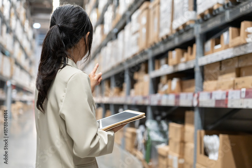 Fotografi asian female business owner using digital tablet check amount of stock product inventory on shelf at distribution warehouse factory