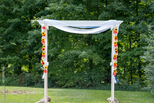 Simple White Wedding Arch with Yellow and Orange Flowers