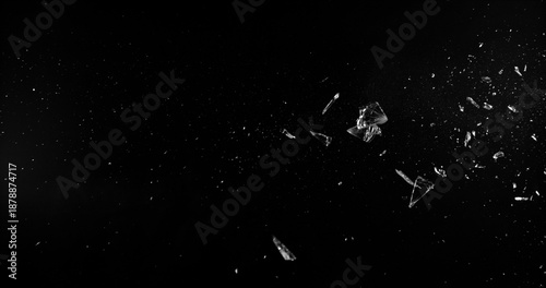 Side angle photo of flying shattered glass shards and dust isolated on black background. High detail debris explosion, perfect for VFX overlay, compositing, transitions or dramatic design elements.
