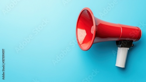 A red and white megaphone on a blue background. The object concept of communication and announcement. The image emphasizes the loudspeaker's vibrant color and the blue background's simplicity.