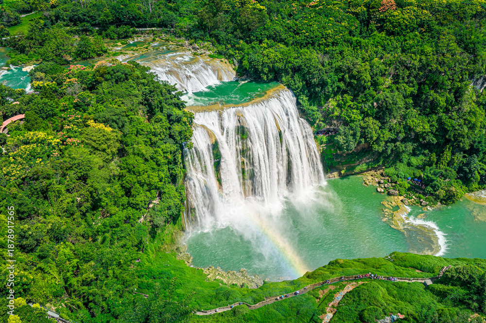 Fototapeta premium Majestic Huangguoshu Waterfall with a rainbow in Guizhou, China during a sunny day.