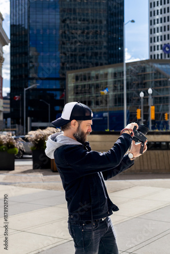Bearded man taking photos in downtown city