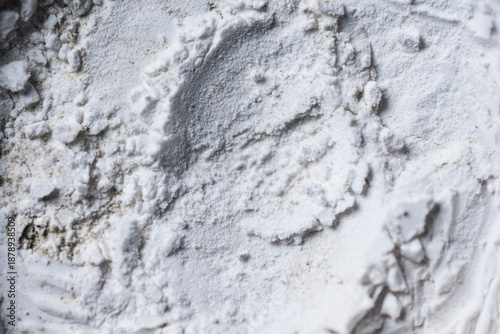 High-resolution macro shot of white powder texture with uneven surface, clumps, and circular patterns. Perfect for abstract backgrounds or representing flour, chalk, or cosmetics