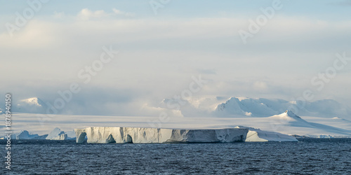Photos A large tabular iceberg in front of snow covered mountains near Cape Legoupil, Antarctica