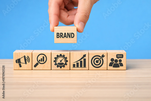 Brand strategy and marketing development concept with business icons and hand placing brand block above
