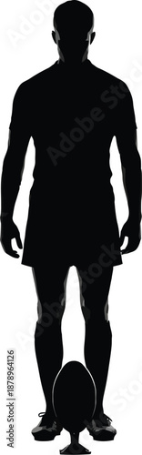 Silhouette of a rugby player standing over a ball placed on a kicking tee ready for a conversion or penalty goal attempt