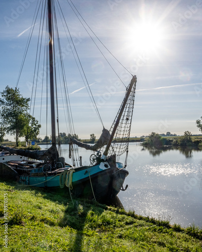 Wallpaper Mural Boat is docked by a river under the sun with trees in the background on a clear day in the morning Torontodigital.ca