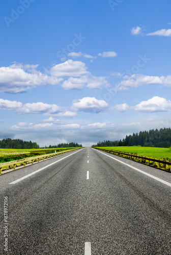 Landstrasse in grüner hügeliger Landschaft