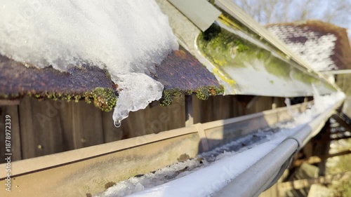 rain gutter with thawing snow and ice
