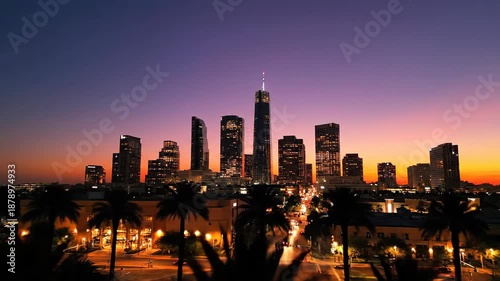 City skyline silhouette against a vibrant dusk sky with palm trees