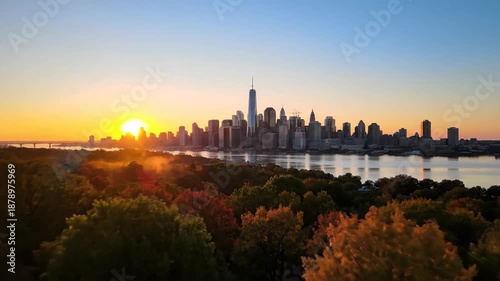 City skyline silhouette at sunrise with water and colorful foliage