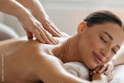 Photos Satisfied lady enjoying back and shoulder massage, spa therapist doing general b