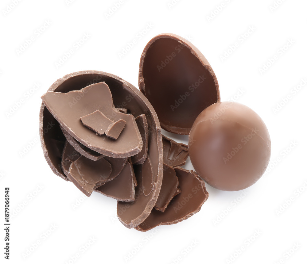 Obraz premium Pieces of tasty chocolate eggs isolated on white, top view. Happy Easter
