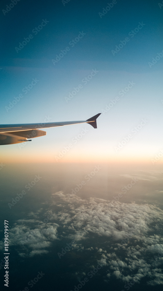 Fototapeta premium Breathtaking View from an Airplane Window, Looking Over White Clouds and Blue Sky in Bright Natural Sunlight