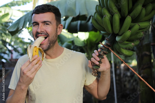 Vászonkép Handsome man eating a banana