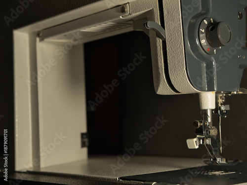 фотографія Close-up shot of a person's hand setting up or repairing an older, classic sewing machine