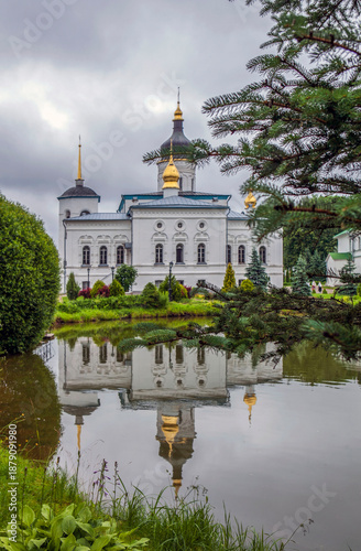 Monastery grounds with a pond and a view of the Cathedral of the Three Holy Hierarchs. Spaso-Eleazarovsky Convent. Elizarovo village, Pskov Oblast, Russia