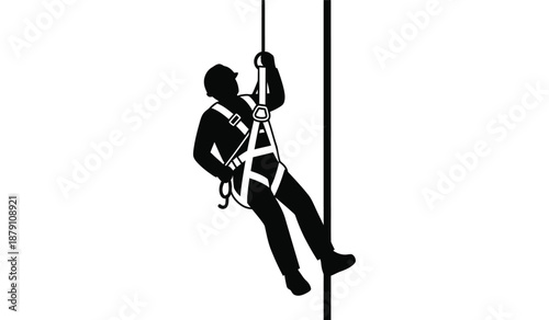 Silhouette of a worker rappelling down a vertical structure with safety harness
