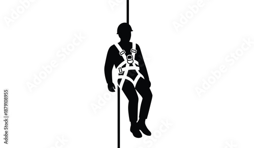 Silhouette of a worker suspended on a rope with safety harness